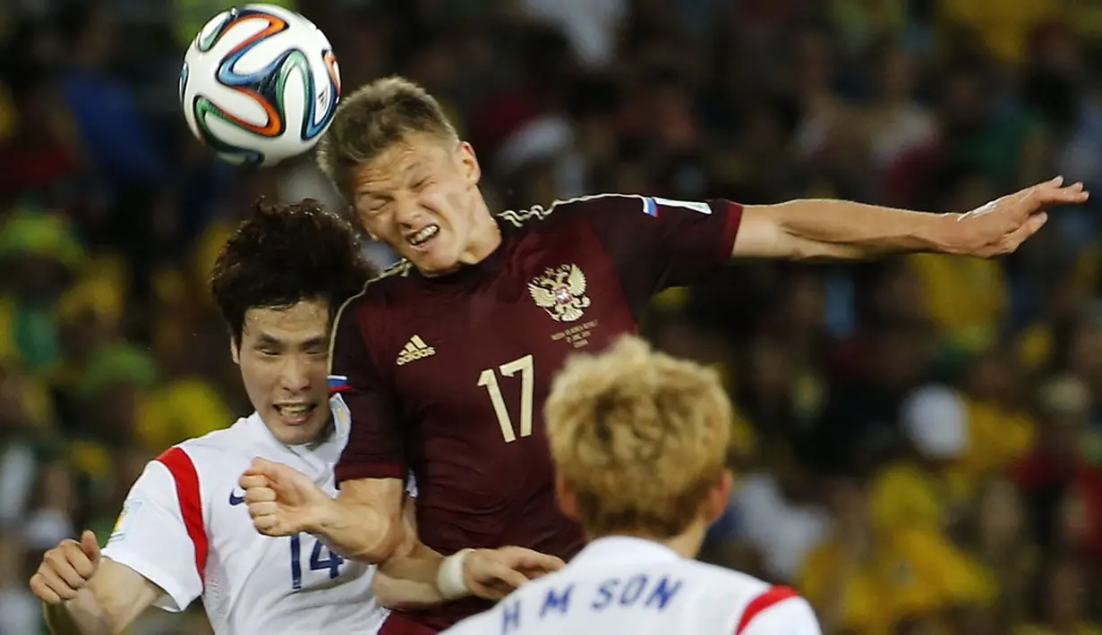 Gelandang Korea Selatan, Kook-Young Han  (kiri) berebut bola dengan Oleg Shatov (Rusia) saat berlaga di babak penyisihan Piala Dunia 2014 Grup H, Pantanal Arena, Cuiaba, Brasil, (18/6/2014). (REUTERS/Eric Gaillard)