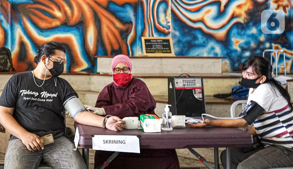 Warga menjalani pemeriksaan kesehatan saat mengikuti vaksinasi COVID-19 Sinovac di Terowongan Kendal, Jakarta Pusat, Jumat (30/7/2021). Total sasaran vaksinasi sebanyak 208.265.720. (Liputan6.com/Faizal Fanani)