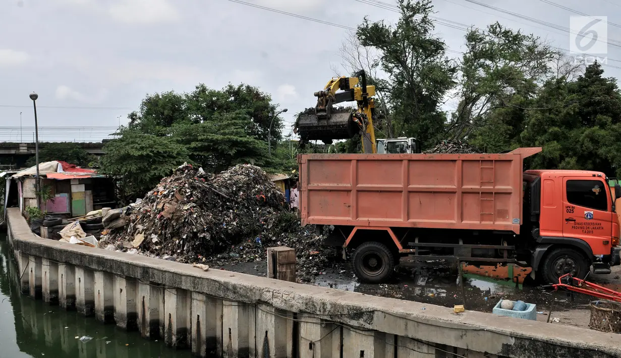 Petugas menggunakan alat berat mengangkut sampah di area proyek Fasilitas Pengolahan Sampah Terpadu atau Intermediate Treatment Facility (ITF) Sunter, Jakarta, Selasa (12/2). ITF Sunter ditargetkan beroperasi pada 2021. (Merdeka.com/Iqbal Nugroho)