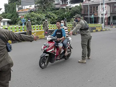 Petugas Satpol PP memberhentikan pengendara sepeda motor saat melakukan razia masker di kawasan Kota Tua, Jakarta, Kamis (24/2/2022). Pemerintah pusat kembali memperpanjang masa PPKM level 3 untuk wilayah Jakarta, Bogor, Depok, Tangerang dan Bekasi (Jabodetabek). (Liputan6.com/Faizal Fanani)