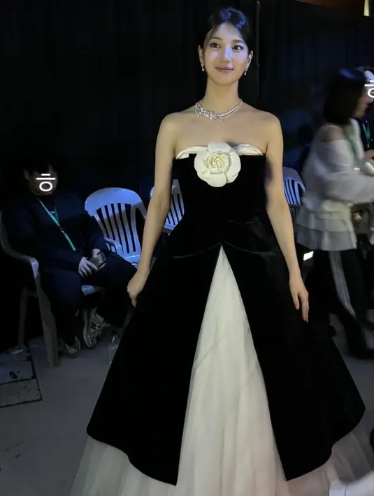 Bae Suzy tampil mengenakan long dress strapless two tone dengan luaran hitam velvet dan rok putih dari Richard Quinn dihiasi bunga putih serta perhiasannya. @skuukzky