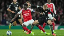 Pemain Arsenal, Bukayo Saka berebut bola dengan pemain Bayern Munchen, Konrad Laimer dalam laga Liga Champions 2025/2026 di Emirates Stadium, London, Rabu (26/11/2025) waktu setempat. (AP Photo/Kin Cheung)