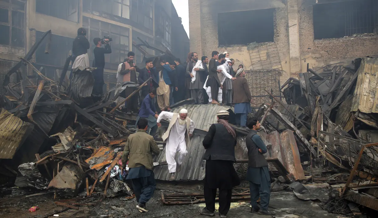 Pemilik toko mencari barang yang tersisa setelah kebakaran di pasar peralatan elektronik di Kabul, Afghanistan (2/11). Warga ibukota Afghanistan bergulat memadamkan kobaran api besar yang menghancurkan ratusan toko. (AP Photo/Massoud Hossaini)
