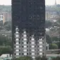 Kerusakan bangunan apartemen Grenfell Tower di London terlihat dari utara Kensington, Minggu (18/6). Gedung apartemen Grenfell Tower yang terbakar pada lepas tengah malam Rabu 14 Juni 2017 lalu dikhawatirkan roboh usai habis dilahap api. (TOLGA AKMEN/AFP)