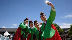 Para wanita muda berswafoto mengenakan pakaian tradisional hanbok setelah upacara “Coming of Age” di Namsan Hanok Village, Seoul, Senin (20/5/2019). Di Korea Selatan, Coming of Age Day atau hari kedewasaan dirayakan secara nasional setiap tahun pada hari Senin ketiga di bulan Mei. (Ed JONES/AFP)