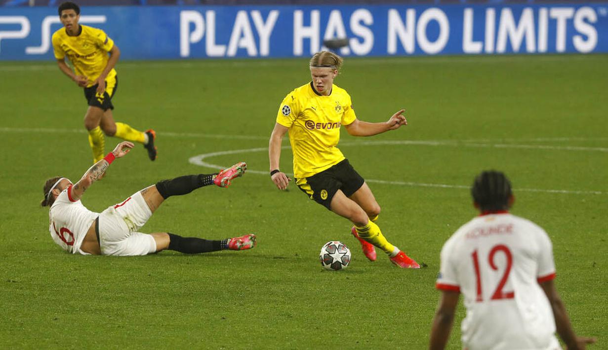 Striker Borussia Dortmund, Erling Haaland, melewati pemain Sevilla, Nemanja Gudelj, pada laga Liga Champions di Stadion Ramon Sanchez Pizjuan, Kamis (18/2/2021). Dortmund menang dengan skor 2-3. (AP/Angel Fernandez)