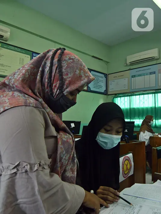 Siswi SMK PB Soedirman jurusan akuntansi melakukan persiapan Uji Sertifikasi Kompetensi (USK) bagi para siswa kelas XII di SMK PB Soedirman, Jakarta, Selasa (6/4/2021). Jumlah murid per hari dibatasi dan dibagi tiga waktu. (Liputan6.com/Herman Zakharia)