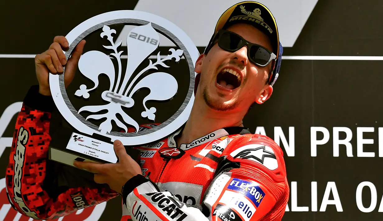 Pembalap Ducati Team, Jorge Lorenzo, merayakan selebrasi di podium setelah memenangkan Moto Grand Prix di Sirkuit Mugello, Italia, Minggu (03/6). Jorge Lorenzo menang atas pembalap Andrea Dovizioso dan Valentino Rossi. (AFP FOTO / Tiziana Fabi)