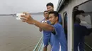 Sejumlah punggawa Persib melakukan selfie saat melintasi Sungai Mahakam menuju Stadion Aji Imbut, Tenggarong, Kaltim, Sabtu (3/10/2015). (Bola.com/Vitalis Yogi Trisna)