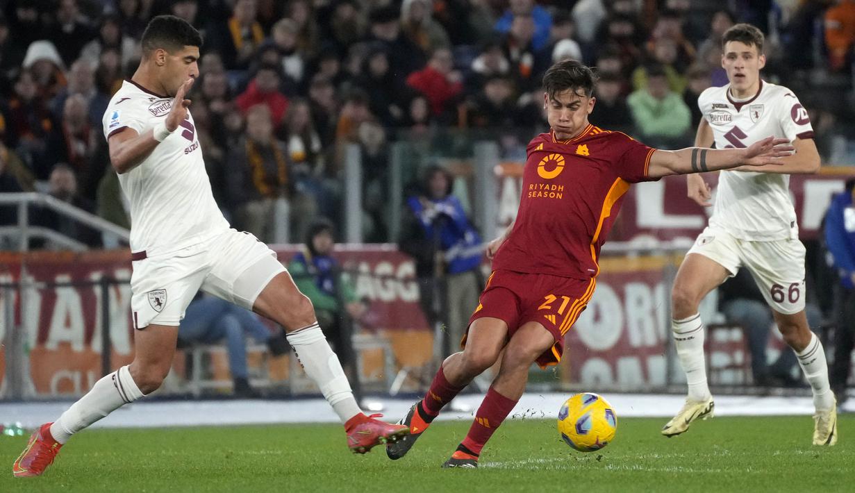 Pemain AS Roma, Paulo Dybala (tengah) berusaha melewati penjagaan pemain Torino, Adam Masina saat laga lanjutan Liga Italia 2023/2024 di Olympic Stadium, Roma, Italia, Selasa, (27/02/2024) dini hari WIB. (AP Photo/Gregorio Borgia)