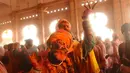 Umat Hindu menari saat bubuk berwarna dilemparkan ke arah mereka di Ladali atau kuil Radha selama festival Lathmar holi di Barsana, India, Selasa (23/3/2021). Perayaan Lathmar Holi berlangsung dari 23 Maret hingga 29 Maret tahun ini. (AP Photo)