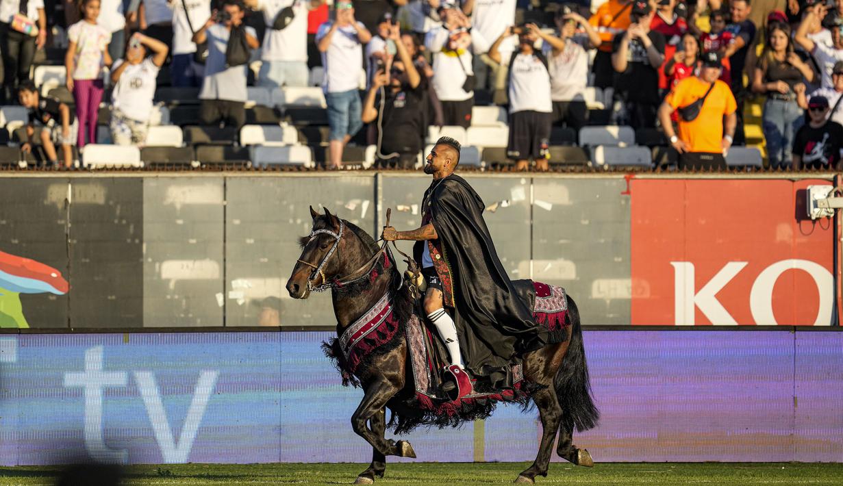 Arturo Vidal menaiki kuda sambil menyapa fans saat diperkenalkan sebagai pemain baru klub Liga Chile, Colo-Colo di Stadion Monumental David Arellano, Chili, Jumat (2/2/2024) WIB. (AP Photo/Esteban Felix)