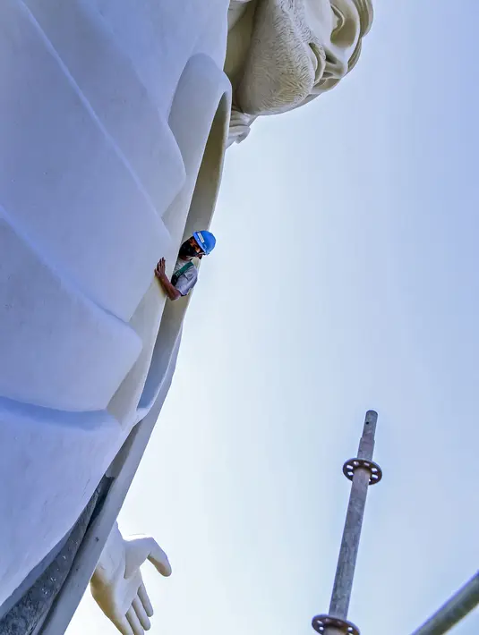 Seorang pekerja terlihat dekat patung Christ the Protector yang sedang dibangun di Encantado, negara bagian Rio Grande do Sul, Brasil, pada 29 Oktober 2021. Patung itu akan lebih besar dari Christ the Redeemer milik Rio de Janeiro dan menjadi tertinggi ketiga di dunia. (SILVIO AVILA / AFP)
