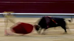 Dalam foto yang diambil dengan kecepatan rana lambat ini, matador Emilio de Justo saat adu banteng di arena adu banteng Las Ventas, Madrid, Spanyol, Minggu (4/7/2021). Adu banteng ini berlangsung di tengah pandemi virus corona COVID-19. (AP Photo/Manu Fernandez)