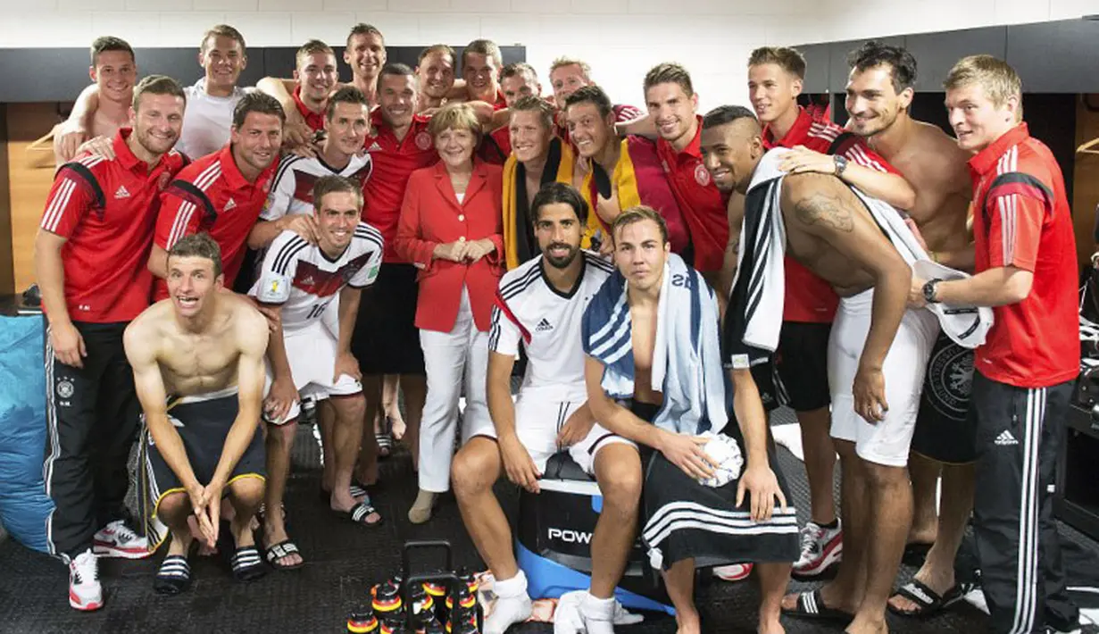 Sebelum meninggalkan Fonte Nova Arena, Salvador, Brasil, (16/6/2014), Kanselir Jerman, Angela Merkel (tengah) berfoto bersama Philipp Lahm dkk di ruang ganti pemain. (AFP PHOTO/Fabrice Coffrini)