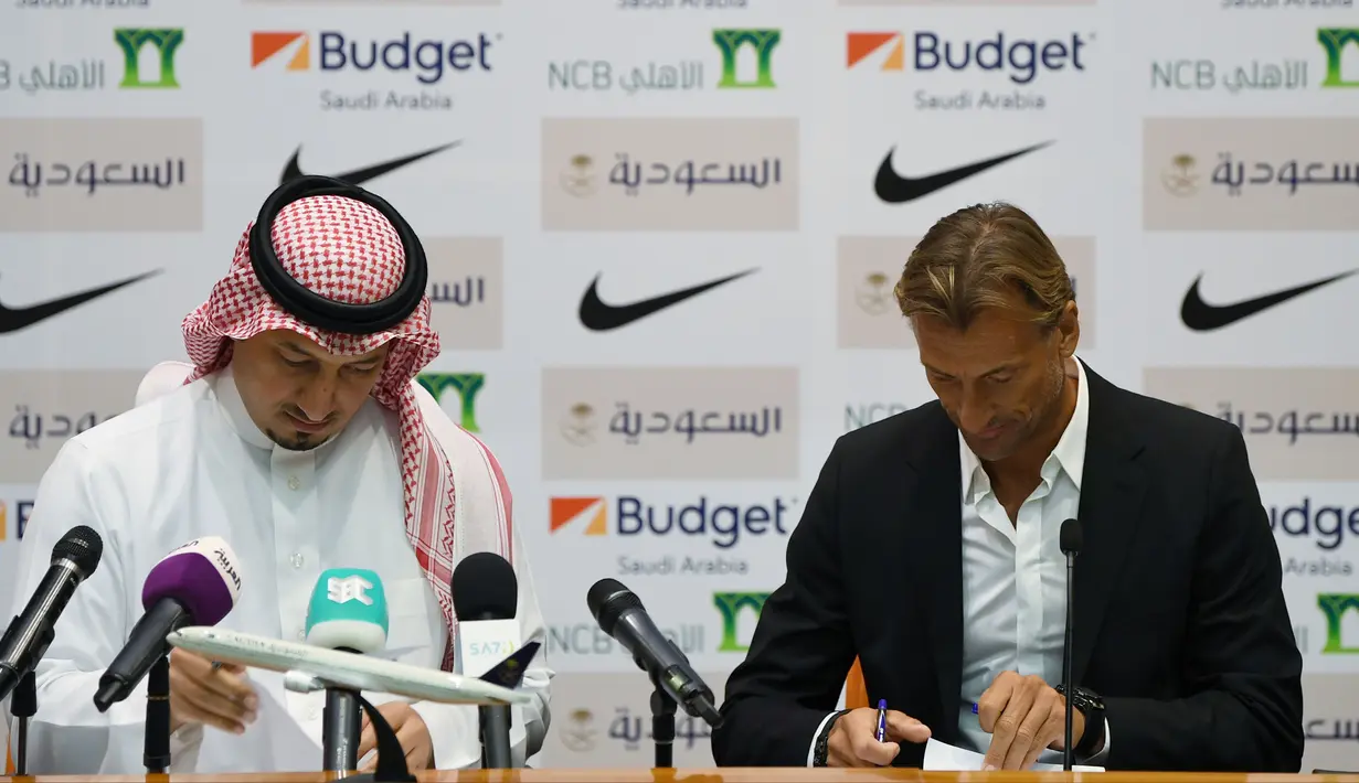 Pelatih asal Prancis, Herve Renard (kanan) didampingi ketua Federasi Sepakbola Saudi Yasser Almisehal saat menandatangani dokumen setelah resmi menjadi pelatih Timnas Arab Saudi di Jeddah (5/8/2019).  (AFP Photo/Amer Hilabi)