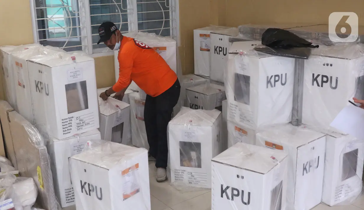 Petugas mengangkat kotak suara pilkada di Parigi, Tangerang Selatan, Selasa (8/12/2020). Petugas Panitia Pemilihan Suara (PPS) mendistribusikan logistik kotak suara ke masing-masing TPS di wilayah tersebut sebagai persiapan Pilkada Tangerang Selatan 2020. (Liputan6.com/Angga Yuniar)