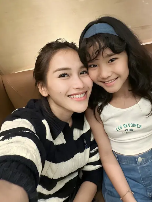 Keseruan gaya fashion lainnya bisa dilihat dengan tampilan ala Y2K. Paduan tanktop putih berpadu denim dan kombinasi bandana denim semakin sempurnakan gaya Balqis yang menggemaskan. [Foto: Instagram/ Ayutingting]