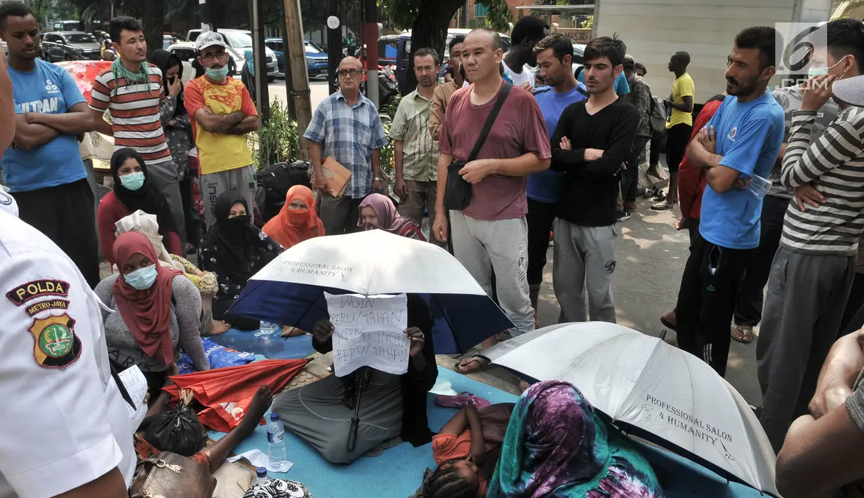Sejumlah imigran saat bertemu dengan perwakilan UNHCR di trotoar depan Kantor UNHCR Menara Ravindo, Kebon Sirih, Jakarta, Rabu (3/7/2019). Kebanyakan dari puluhan imigran tersebut merupakan laki-laki, sebagian lagi perempuan dan anak-anak. (merdeka.com/Iqbal Nugroho)