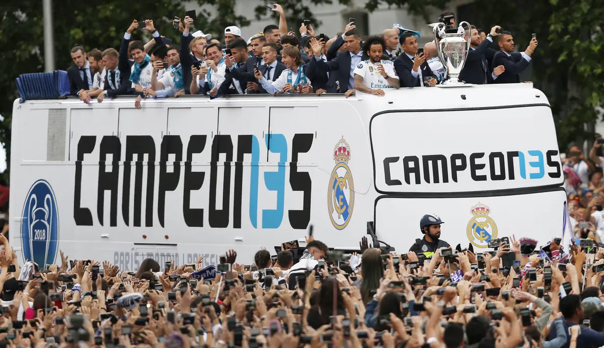 Para pemain Real Madrid menyapa fans saat merayakan kemenangan Liga Champions di Monumen Cibeles, Madrid, Minggu (27/5/2018). Real Madrid menggelar pawai kemenangan bersama fans usai menjuarai Liga Champions 2018. (AP/Francisco Seco)