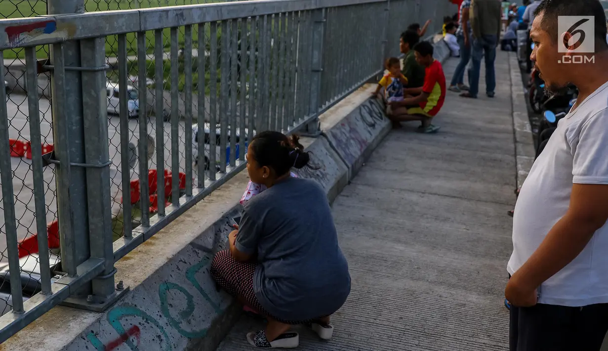 Warga melihat kemacetan arus lalu lintas di Gerbang Tol Utama Palimanan, Cirebon, Jawa Barat, Kamis (29/6). Menjelang sore hari warga berwisata sambil menyaksikan kemacetan volume kendaraan saat arus balik menuju Jakarta. (Liputan6.com/Faizal Fanani)