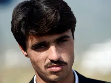 Seorang penjual teh, Arshad Khan memberi keteranganan  pada awak media di Islamabad, Pakistan (20/10). Khan mendadak terkenal di media sosial setelah fotonya tersebar luas. (AFP/Farooq Naeem)