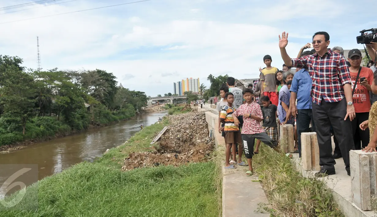 Cagub DKI Basuki Tjahaja Purnama ( Ahok ) menyapa warga dari pinggir sungai saat blusukan ke wilayah Cililitan, Jakarta, Rabu (28/12). Dalam blusukannya tersebut Ahok mencari tahu permasalahan banjir di Cililitan Kecil. (Liputan6.com/Yoppy Renato)