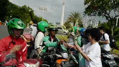 Gemabudhi membagikan bunga kepada pengguna jalan di depan Istana Negara, Jakarta, Sabtu (6/1). Aksi membagikan 2.561 tangkai bunga sedap malam tersebut dilakukan dalam rangka memperingati Hari Raya Trisuci Waisak 2561 B.E. (Liputan6.com/Immanuel Antonius)