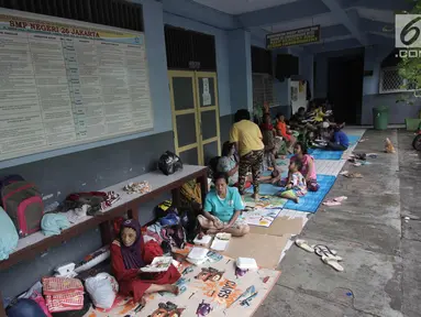 Warga yang rumahnya terendam banjir mengungsi di Gedung SMP Negeri 26, Jalan Kebon Pala, Kampung Melayu, Jatinegara, Jakarta Timur, Selasa (6/2). Sebanyak 42 KK mengungsi di tempat tersebut. (Liputan6.com/Arya Manggala)