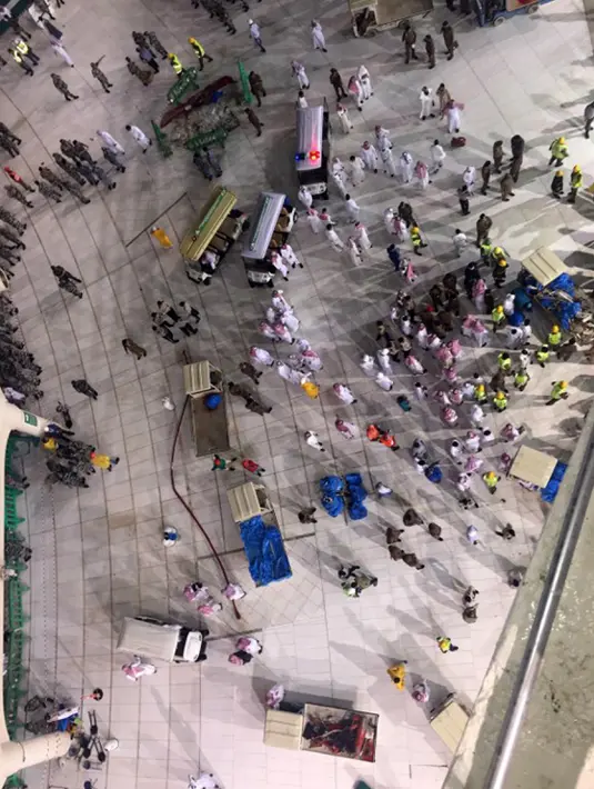 Sejumlah petugas berkumpul di dekat kerusakan yang disebabkan jatuhnya alat berat proyek (crane) di Masjidil Haram, Mekkah, Jumat (11/9/2015). Sebanyak 107 orang dilaporkan tewas, termasuk warga negara Indonesia. (AFP PHOTO / STR)