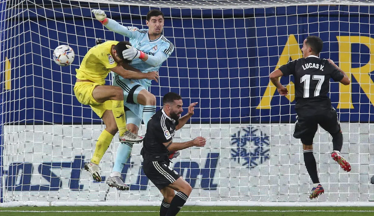 Kiper Real Madrid, Thibaut Courtois, berebut bola dengan pemain Villarreal, Gerard Moreno, pada laga Liga Spanyol di Stadion Ceramica, Minggu (22/11/2020). Kedua tim bermain imbang 1-1. (AP/Alberto Saiz)
