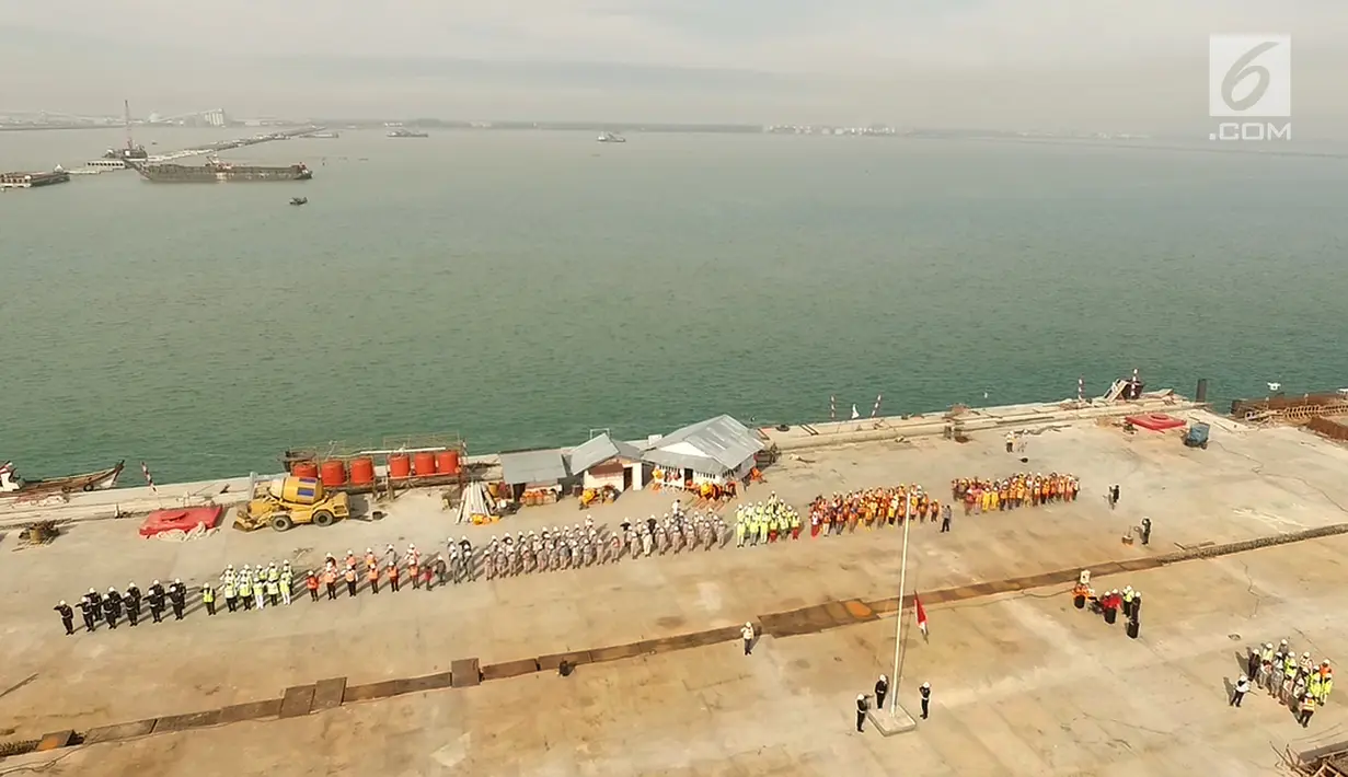  Sejumlah karyawan PT Prima Multi Terminal (PMT) mengikuti upacara bendera HUT RI ke 72 di proyek pembangunan dermaga Pelabuhan Kuala Tanjung di Kabupaten Batubara, Sumatera Utara, Kamis (17/8). (Liputan6.com/Pool)