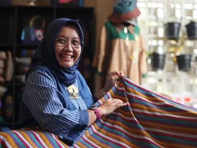 Peni Budi Astuti, pendiri diOpeni, menunjukkan salah satu produk berbahan kain lurik di Malang, Jawa Timur. Usaha ini berkembang dari skala rumahan menjadi UMKM yang memberdayakan perempuan di sekitarnya.