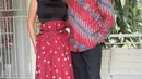 Menyelaraskan batik yang dipakai Giring, Cynthia kenakan dress merah dengan aksen korset.  [Foto: Instagram/ Cynthia Ganesha]