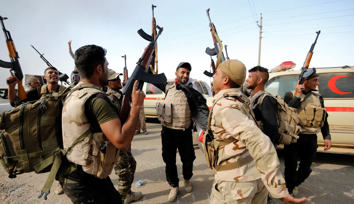 Sejumlah pasukan keamanan Irak bergembira merayakan keberhasilan merebut desa Khalidiya dari ISIS di, selatan Mosul, Irak, (20/10). (REUTERS/Thaier Al-Sudani)