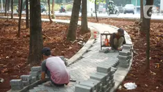 Pekerja menyelesaikan pembuatan jogging track di Taman Citra PPSU Srengseng Sawah, Jakarta, Rabu (4/12/2019). Jogging track tersebut dibuat guna meningkatkan kenyamanan bagi warga yang ingin beraktivitas di taman tersebut. (Liputan6.com/Immanuel Antonius)