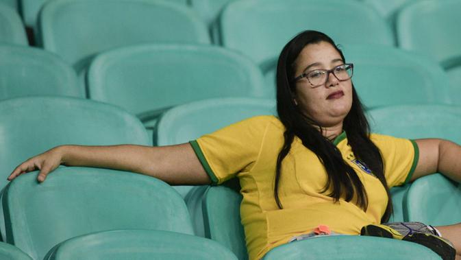 Ekspresi suporter Brasil yang tampak tidak bersemangat saat memyaksikan laga Brazil vs Venezuela di Arena Fonte Nova, Salvador, Brasil. (AP/Natacha Pisarenko)