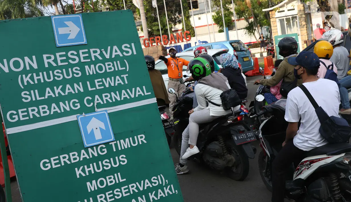 Petugas mengatur kendaraan antre memasuki kawasan Taman Impian Jaya Ancol, Jalarta, Kamis (29/10/2020). Selain tingginya minat warga berwisata di masa libur panjang, antrean ini juga disebabkan pengalihan buka tutup pintu masuk kawasan Taman Impian Jaya Ancol.  (Liputan6.com/Helmi Fithriansyah)