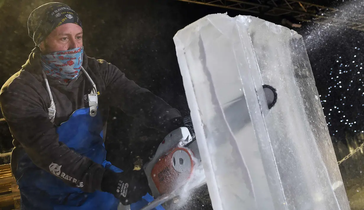 Pemahat es Alex Greenhalgh membelah es untuk membuat patung sebelum melangsungkan pameran bertema "The Ice Adventure: A Journey Through Frozen Scotland" di Edinburgh, Skotlandia (14/11). (AFP Photo/Andy Buchanan)