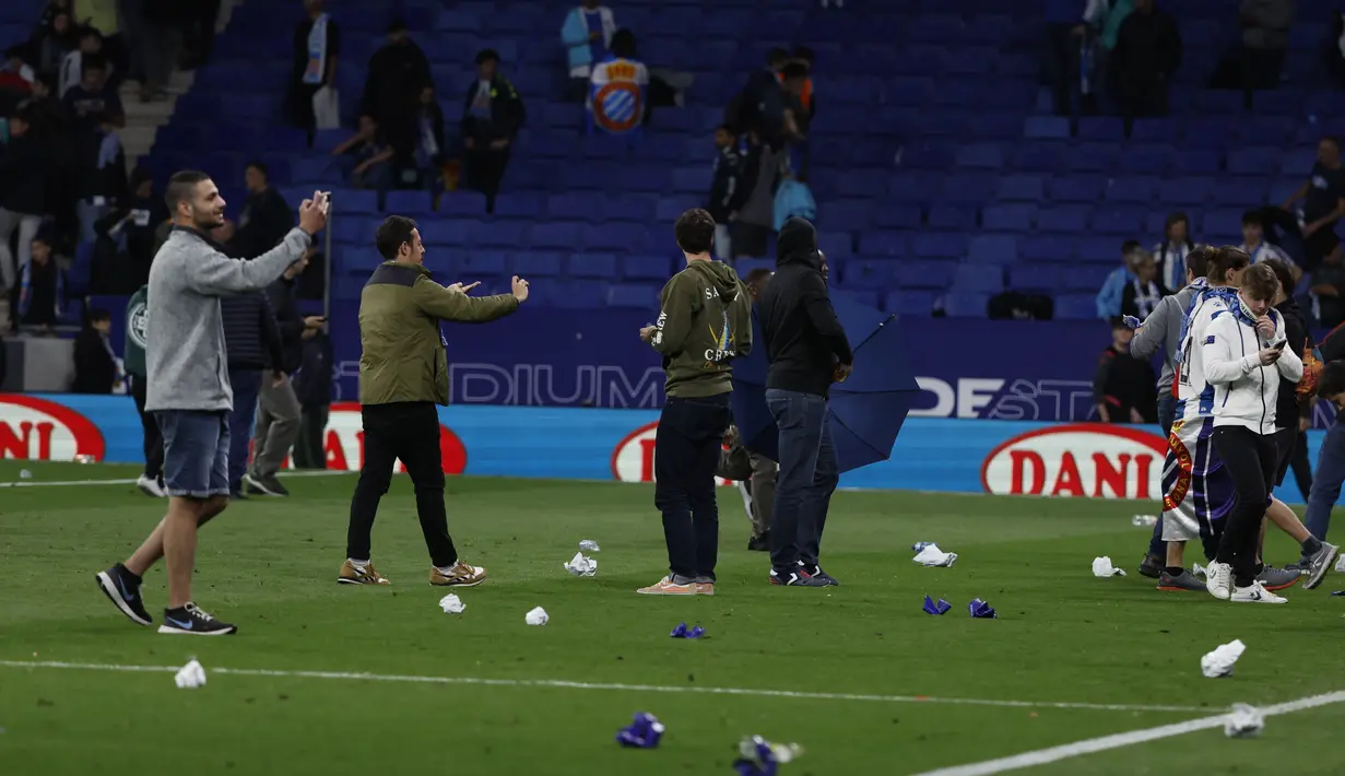 Para suporter berlarian setelah pertandingan La Liga Spanyol antara Espanyol dan Barcelona di stadion RCDE, ​​Senin (15/5/2023) dini hari WIB. (AP Photo/Joan Monfort)