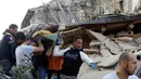 Seorang pria dengan keadan hidup dibawa usai tertimbun reruntuhan akibat gempa dahsyat menghantam kota Amatrice, Italia tengah, (24/8). Gempa menyebabkan kerusakan besar dan getarannya membuat panik penduduk yang sedang tertidur. (REUTERS/Remo Casilli) 