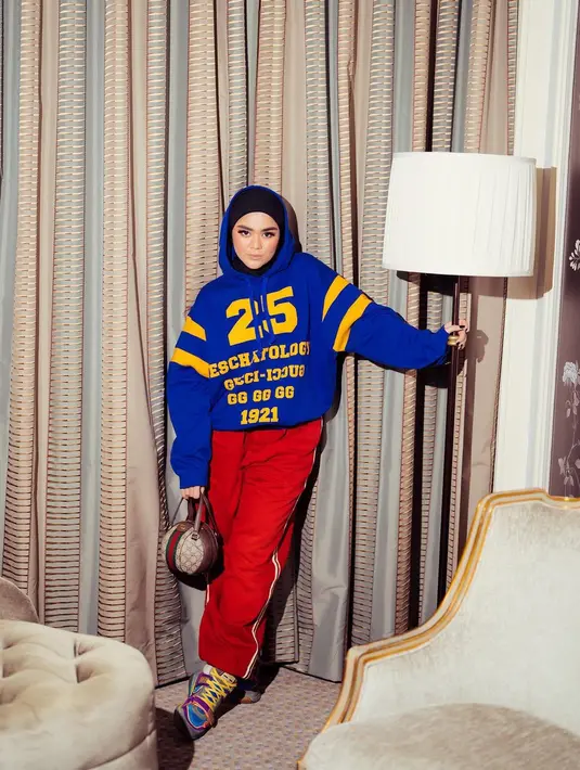 Buat para hijabers, gaya Sivia Azizah yang memadukan hoodie warna biru dengan lounge pants merah serta sneakers warna-warni bisa jadi tampilan streetwear yang trendy dan stylish. (Instagram/siviazizah).