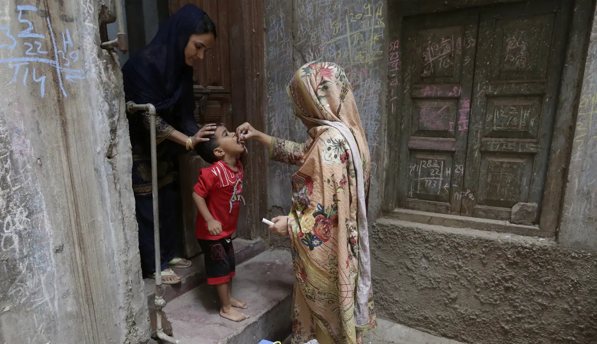<p>Petugas kesehatan memberikan tetes vaksin polio kepada seorang anak saat kampanye vaksinasi polio dari rumah ke rumah di lingkungan Lahore, Pakistan, Senin (23/5/2022). Pakistan meluncurkan upaya anti-polio baru pada hari Senin, lebih dari seminggu setelah pejabat mendeteksi kasus ketiga tahun ini di wilayah barat laut negara itu yang berbatasan dengan Afghanistan. (AP Photo/K.M. Chaudary)</p>