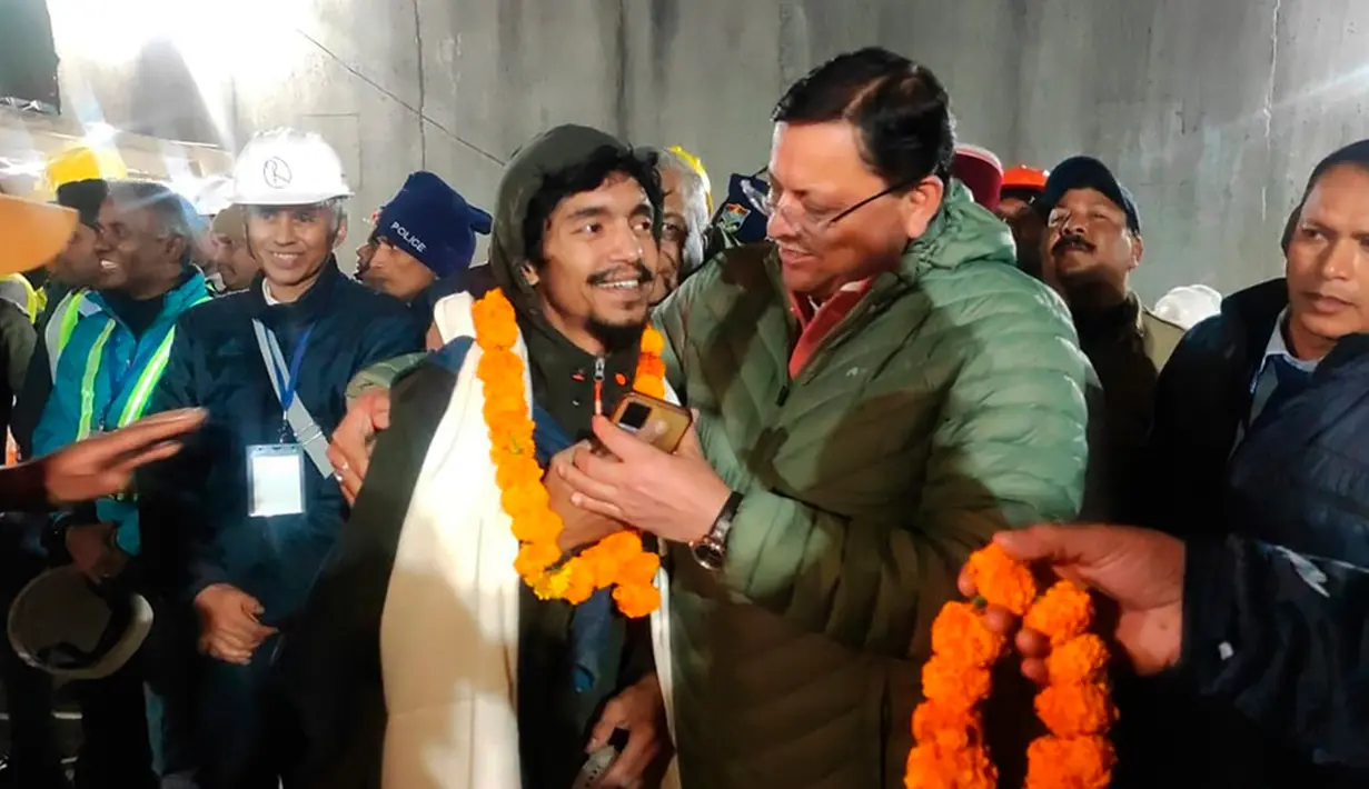 Sejumlah teman, keluarga, dan penduduk setempat berkumpul di luar terowongan, menyalakan petasan dan membagikan permen. (Uttarakhand State Department of Information and Public Relations via AP)