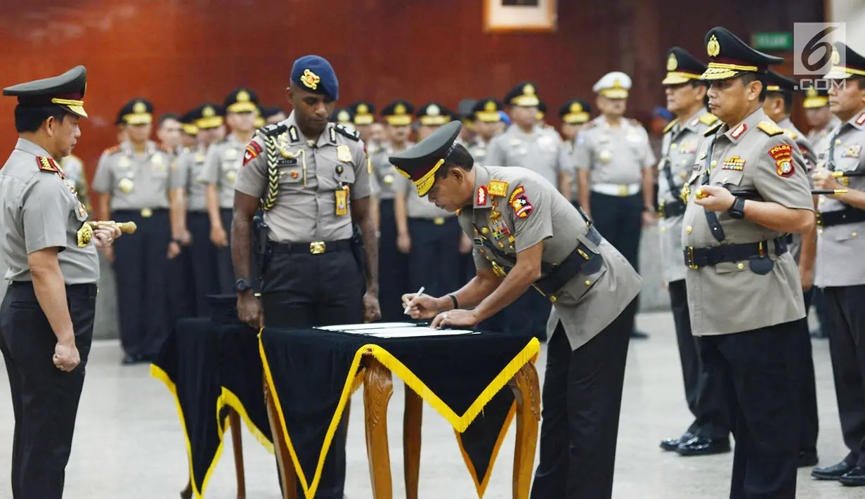 Kapolri Jenderal Tito Karnavian (kiri) menyaksikan Kabareskrim Irjen Pol Idham Azis menandatangani dokumen saat sertijab di Jakarta, Kamis (24/1). Tito memimpin langsung sertijab 17 perwira tinggi Polri. (Merdeka.com/Imam Buhori)