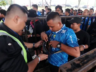 Petugas keamanan mememeriksa tas dari seorang pendukung Persib Bandung sebelum laga leg 1 final Championship Series BRI Liga 1 2023/2024 melawan Madura United di Stadion Si Jalak Harupat, Bandung, Minggu (26/05/2024). (Bola.com/Muhammad Iqbal Ichsan)