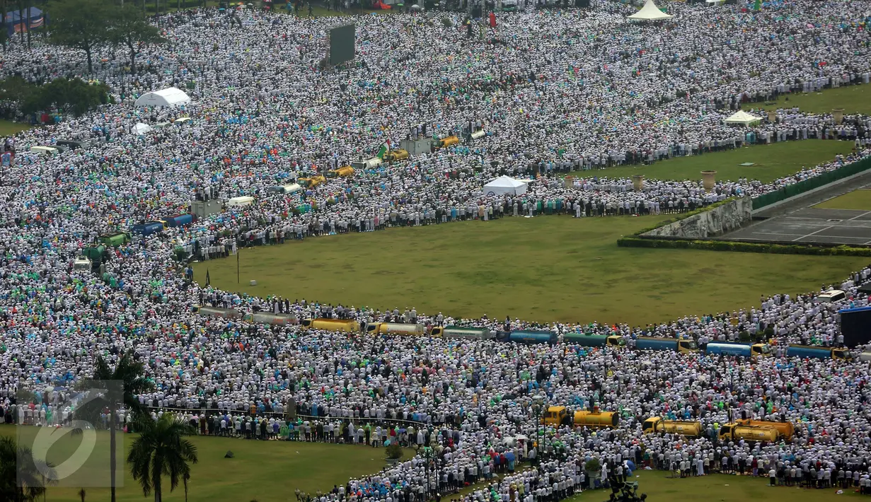 Massa aksi damai 2 Desember bergerak meninggalkan Kawasan Monas setelah melaksanakan Salat Jumat, Jakarta, Jumat (2/12). Massa yang bergerak pulang terus mengumandangkan salawat sambil mengibarkan panji-panji mereka. (Liputan6.com/Johan Tallo)