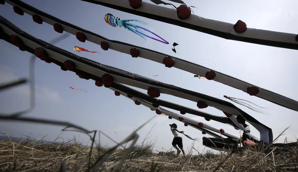 Seorang anak laki-laki mengambil bagian dalam Varvara Kite Fest di Desa Varvara, pesisir Laut Hitam, Bulgaria, Jumat (27/8/2021). Penyelenggara Varvara Kite Fest Andrey Kulev mengatakan bahwa menerbangkan layang-layang seperti melepaskan semua masalah Anda di langit. (AP Photo/Valentina Petrova)
