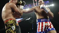 Petinju Inggris Tyson Fury melepaskan pukulan ke wajah Tom Schwarz, dari Jerman dalam pertandingan tinju kelas berat di Las Vegas, Minggu (16/6/2019). (Foto AP / John Locher)