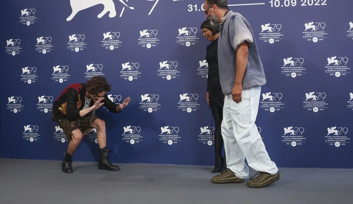 Timothee Chalamet (kiri) membungkuk di depan sutradara Luca Guadagnino (kanan) saat mereka berpose dengan Taylor Russell pada sesi pemotretan untuk film 'Bones and All' selama Venice Film Festival 2022 ke-79 di Venesia, Italia (2/9/2022). (Photo by Joel C Ryan/Invision/AP)